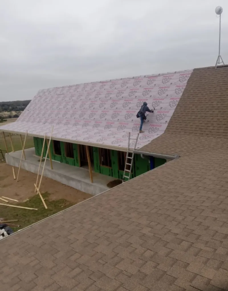 Worker preparing underlayment for a metal roof installation in Lititz